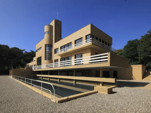 Vue en perspective de la Villa Cavrois à Croix, architecture moderniste en briques jaunes avec bassin et garde-corps blancs.