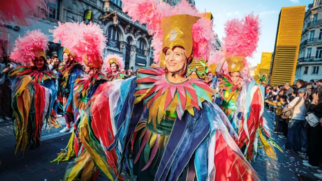 Danseuses en costumes multicolores et coiffes à plumes roses défilant lors de la 7ᵉ édition de la parade Fiesta lille3000.