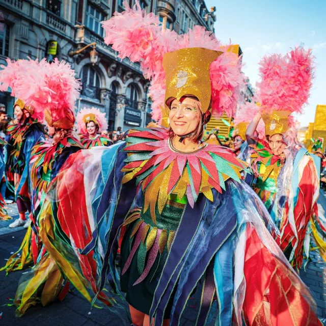 Danseuses en costumes multicolores et coiffes à plumes roses défilant lors de la 7ᵉ édition de la parade Fiesta lille3000.